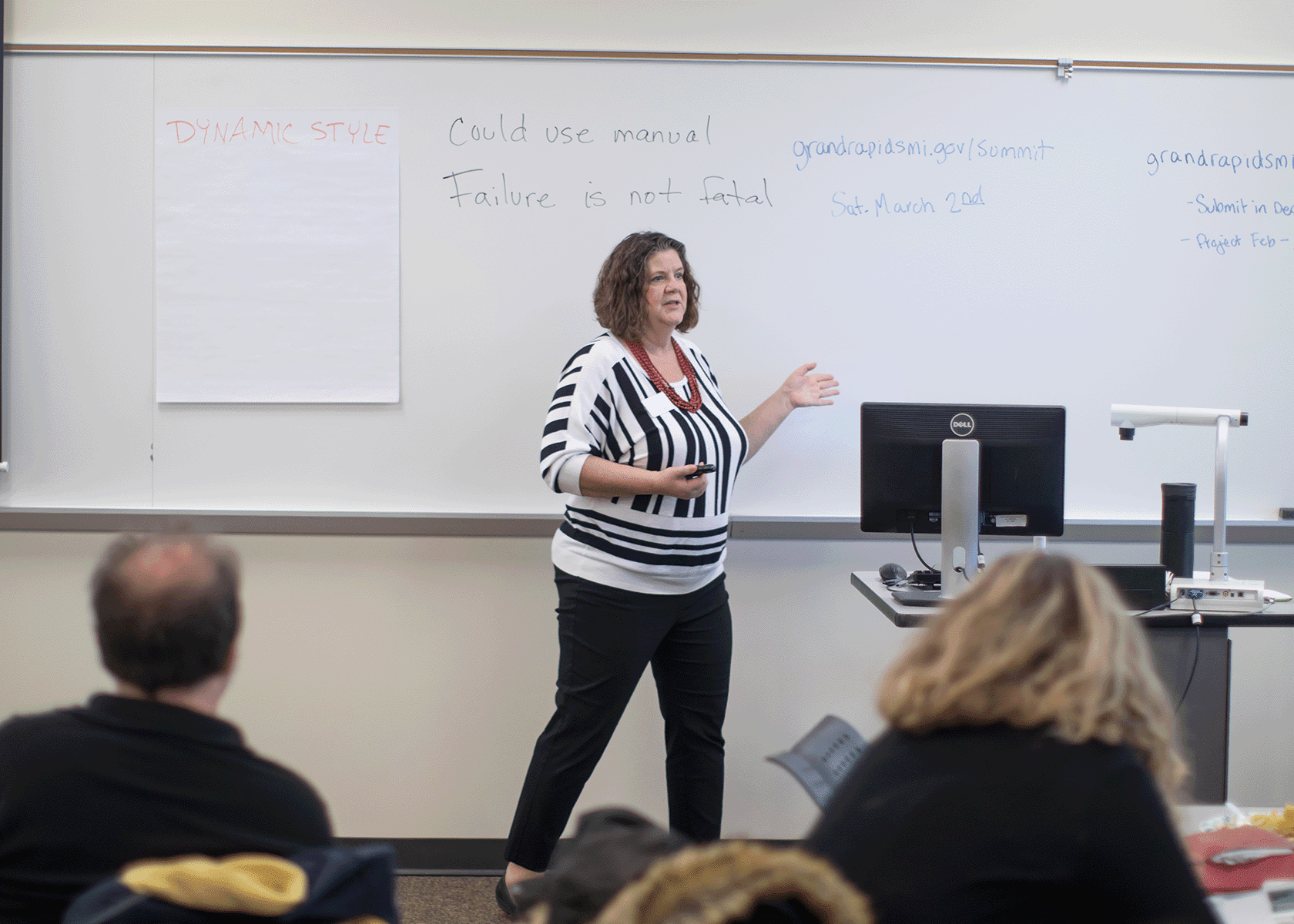 woman presenting with a whiteboard behind her