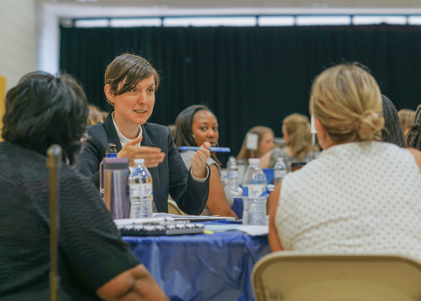 a woman talking to colleages at a table