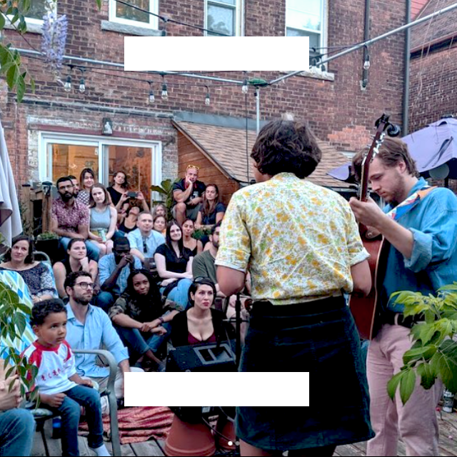 A band plays music to a crowd in a yard