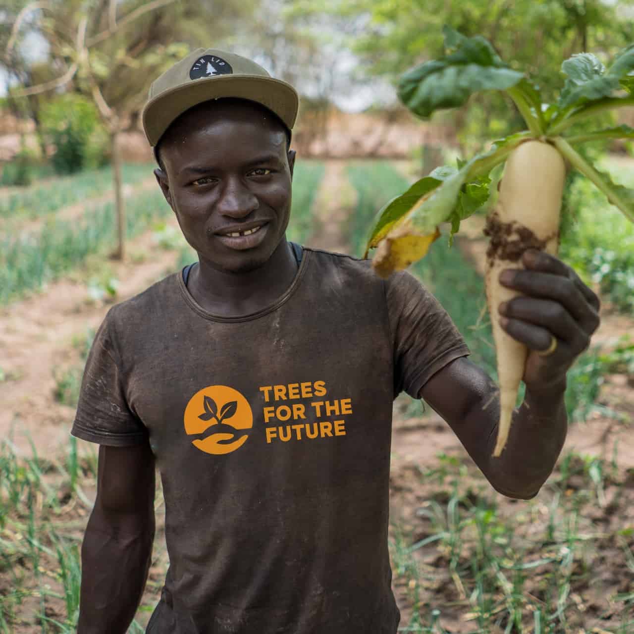 man holding a tree and smiling