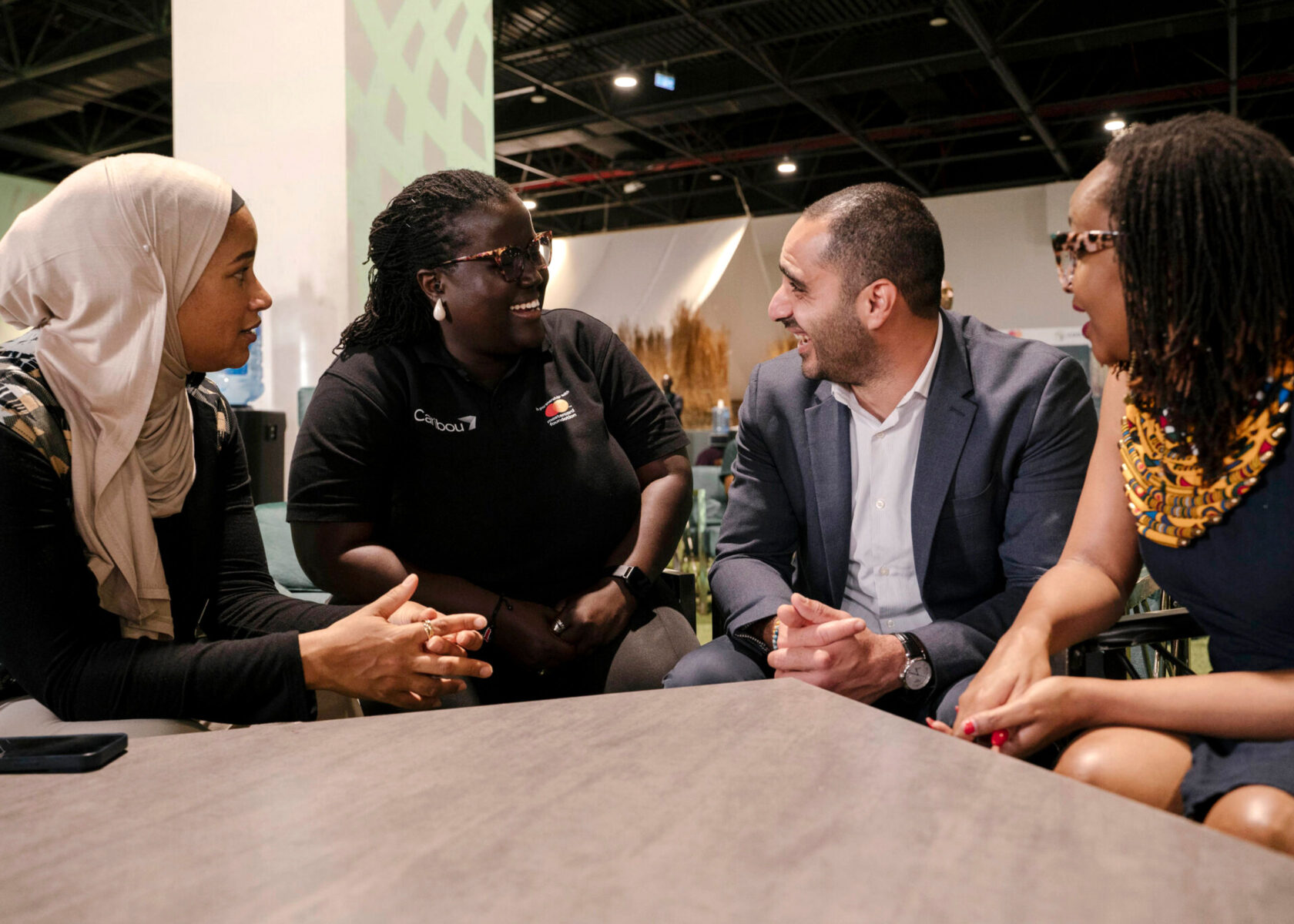 four professional-aged people of various ethnicities conversing animatedly