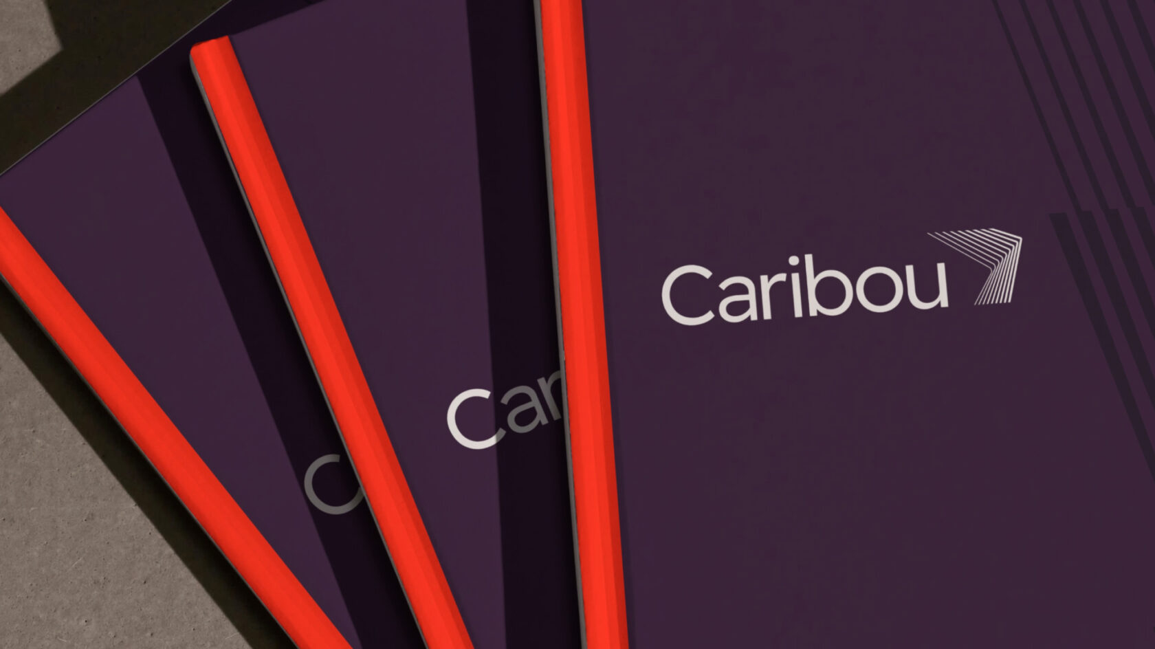 three purple notebooks with the caribou logo